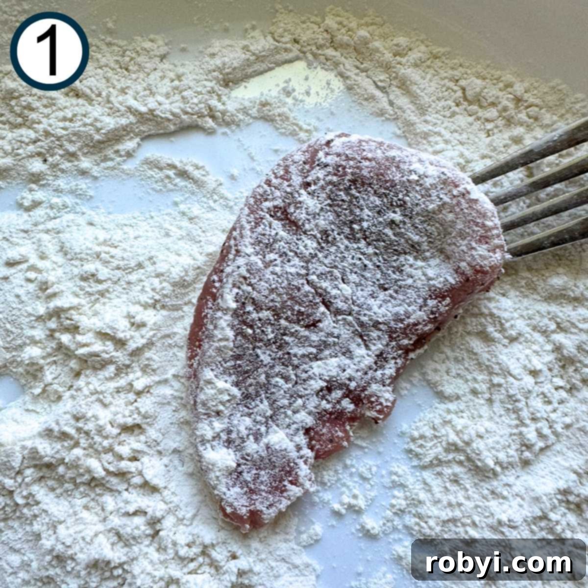 Tork holding a pork medallion lightly dusted in flour over a shallow bowl with flour.