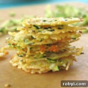 Crispy Parmesan Veggie Bites 8 Seven Parmesan Cheese Crisps oven-baked with shredded zucchini and carrot mixed in added stacked in a pile.
