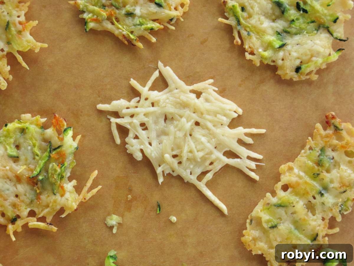 Crispy Parmesan Veggie Bites 5 Keto Parmesan Cheese Crisp made with only Parmesan cheese in the center of a cutting board. The other crisps are made with vegetables.