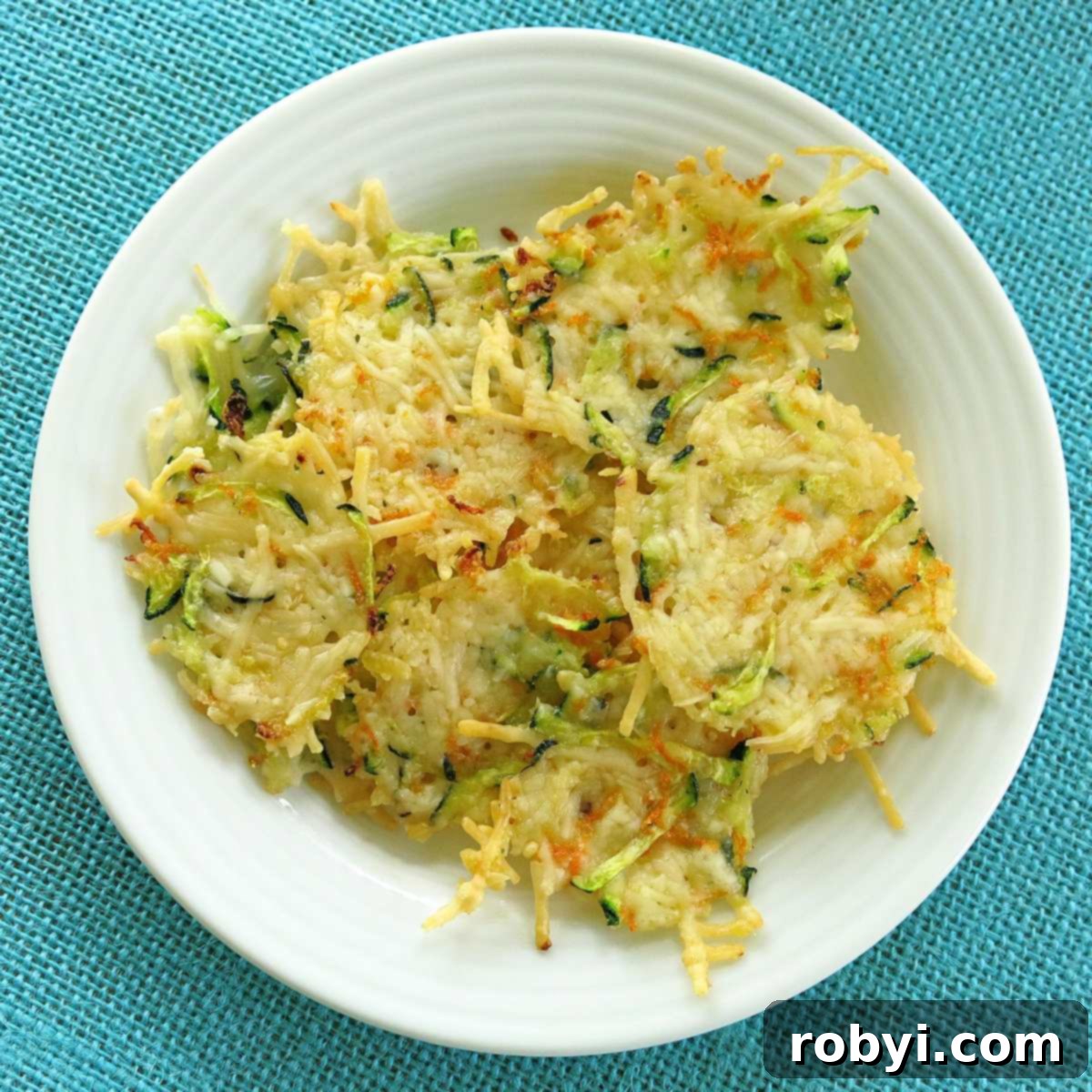 Crispy Parmesan Veggie Bites 6 Overhead shot of parmsan zucchini and carrot chips on a white plate.