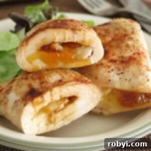 Chicken roulades filled with mango chutney and brie on a plate.