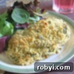 Host a Friendsgiving Feast for Less 3 Parmesan Herb-Crusted Chicken on a plate with salad greens.