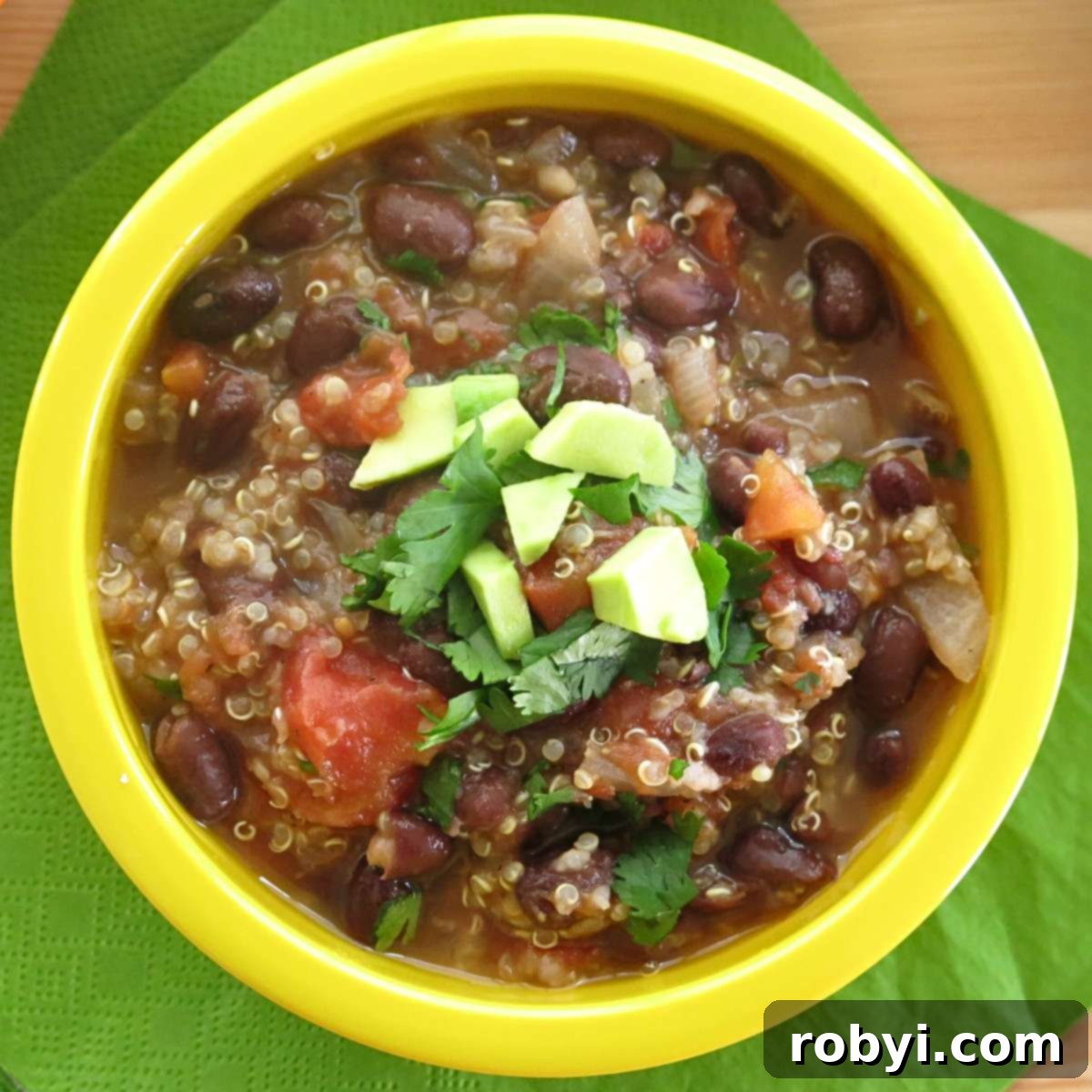 Quick & Hearty Black Bean Quinoa Soup 3 Close-up of a serving bowl filled with Easy Mexican Black Bean Quinoa Soup, beautifully topped with creamy avocado slices and fresh cilantro.
