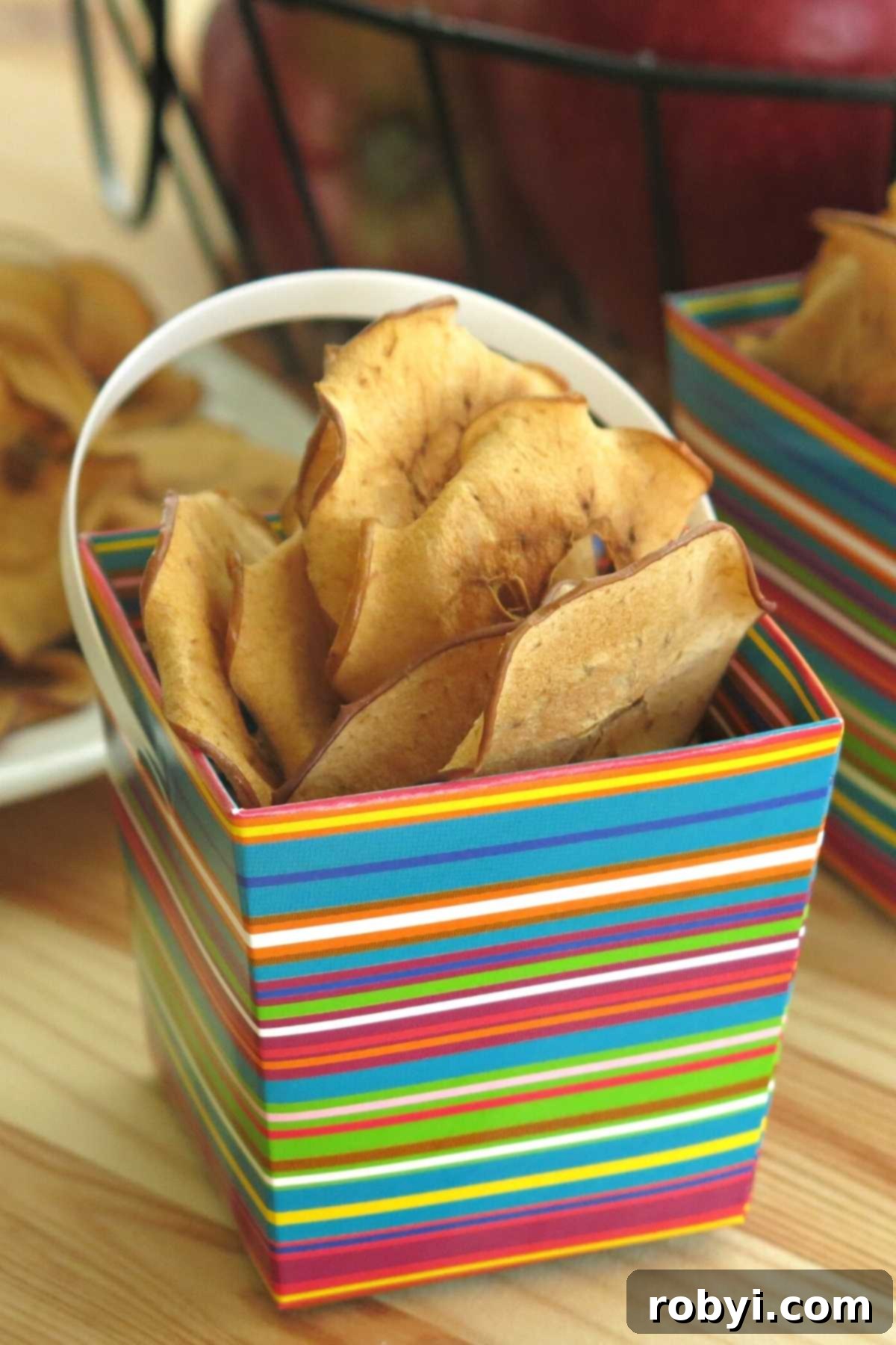 Homemade Crispy Apple Chips 6 Baked apple chips in a colorful serving box.