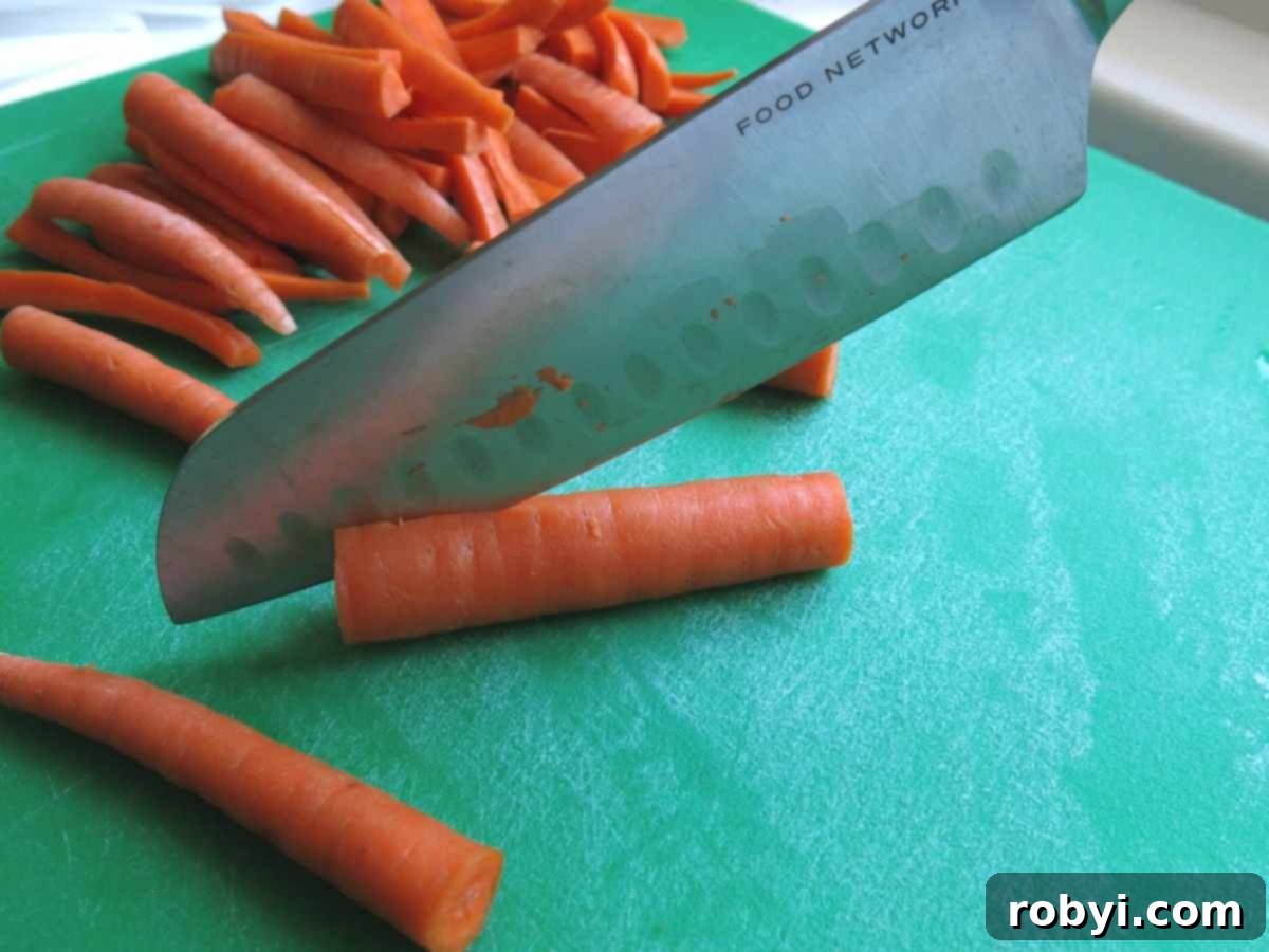 Detailed image showing how to cut carrots into uniform french fry shapes on a cutting board.