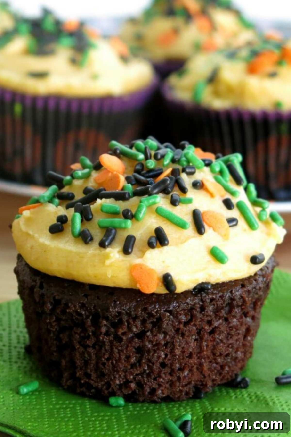 Chocolate Pumpkin Cupcakes with pumpkin buttercream frosting topped with sprinkles.