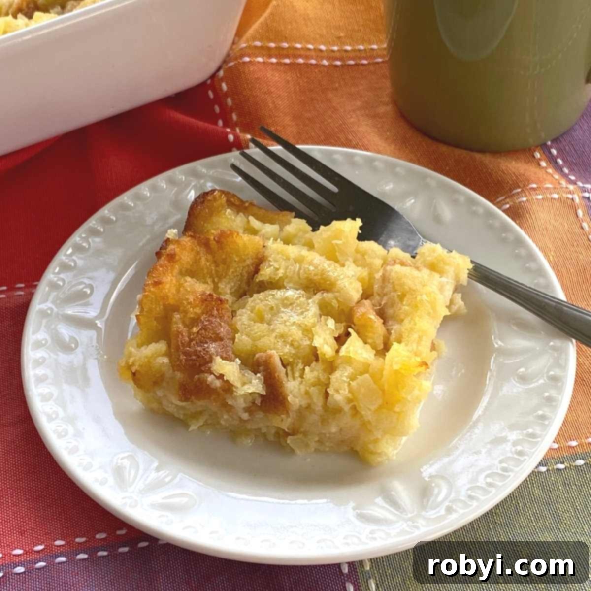 Serving of pineapple souffle on a plate with a fork.