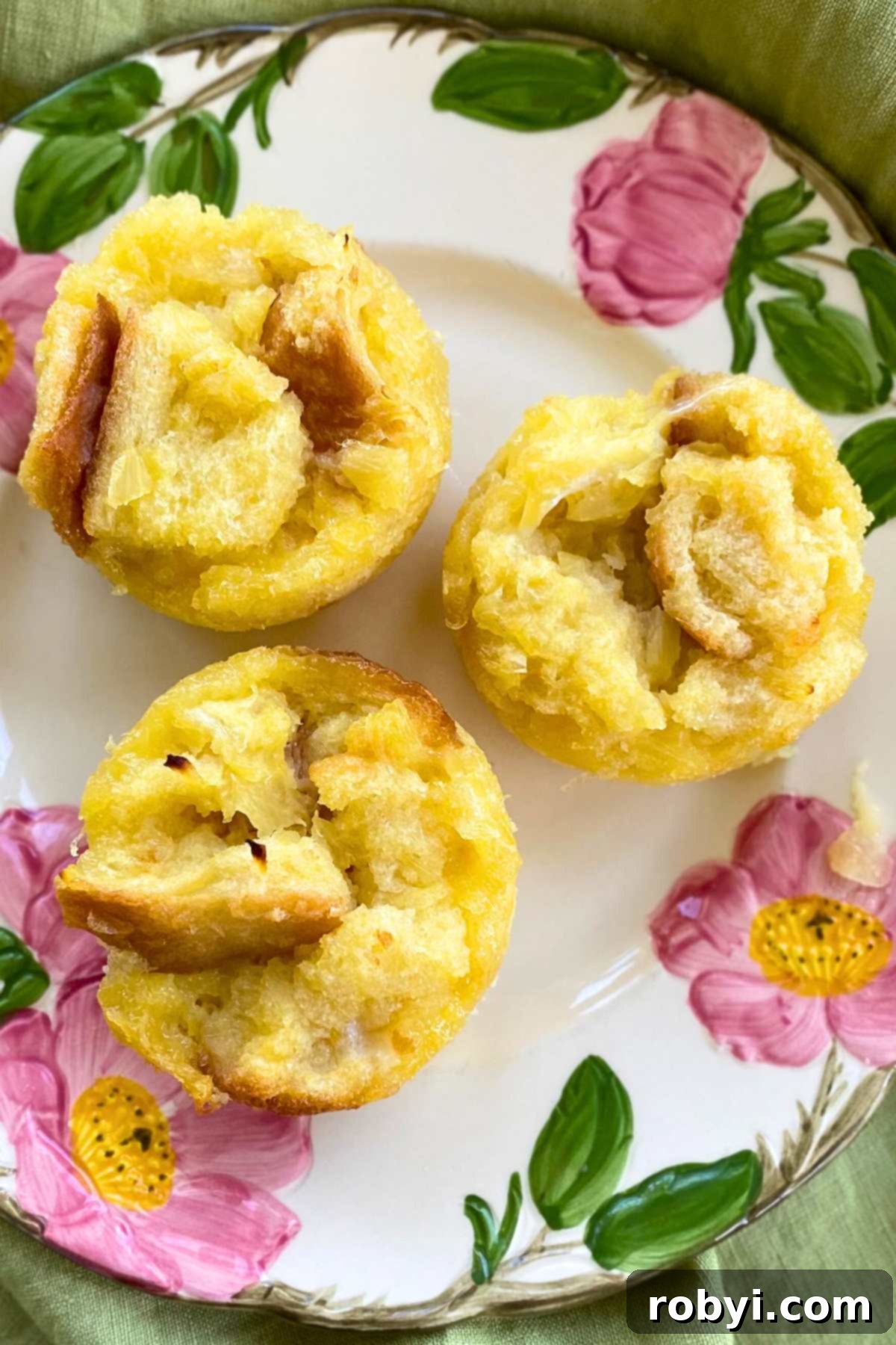 Three pineapple souffle muffins on a plate.
