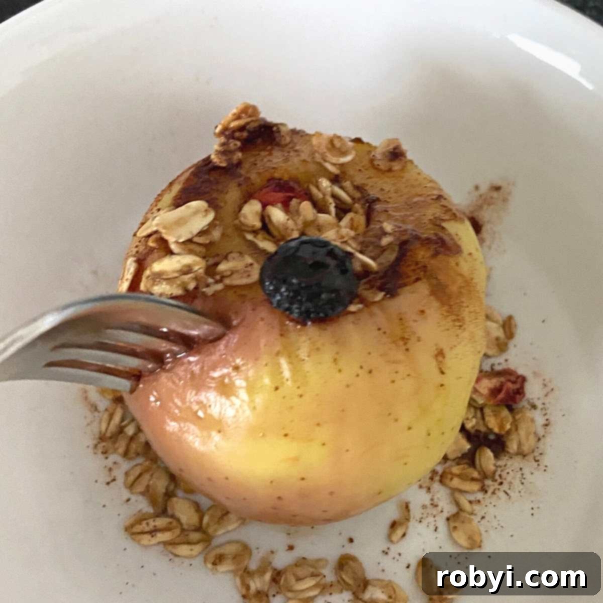 Warm Apples in Minutes 5 A fork piercing the tender skin of a perfectly cooked apple, demonstrating its readiness.