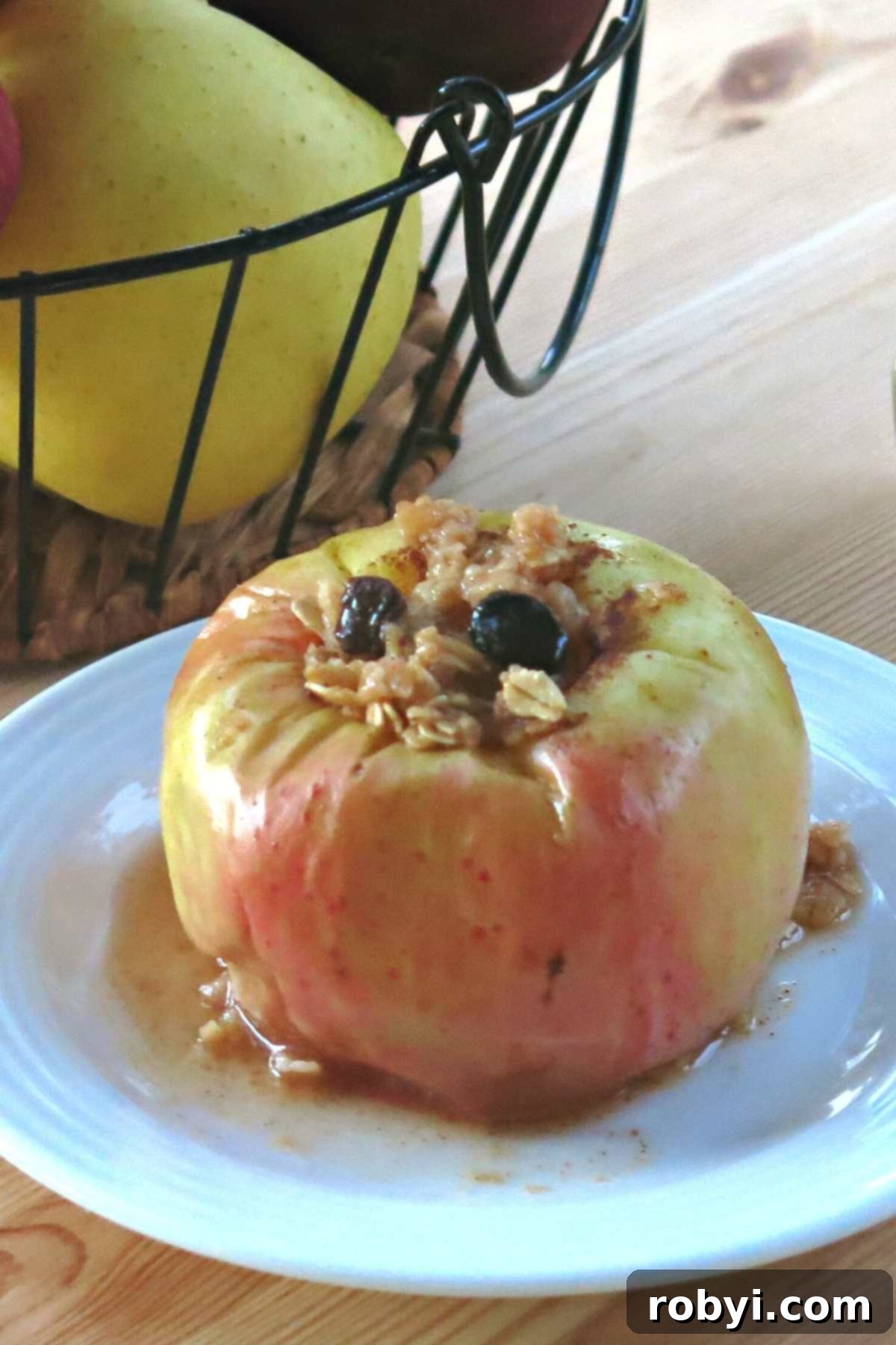 Warm Apples in Minutes 6 A whole microwave baked apple on a plate, with golden juices pooled around it, ready to be eaten.