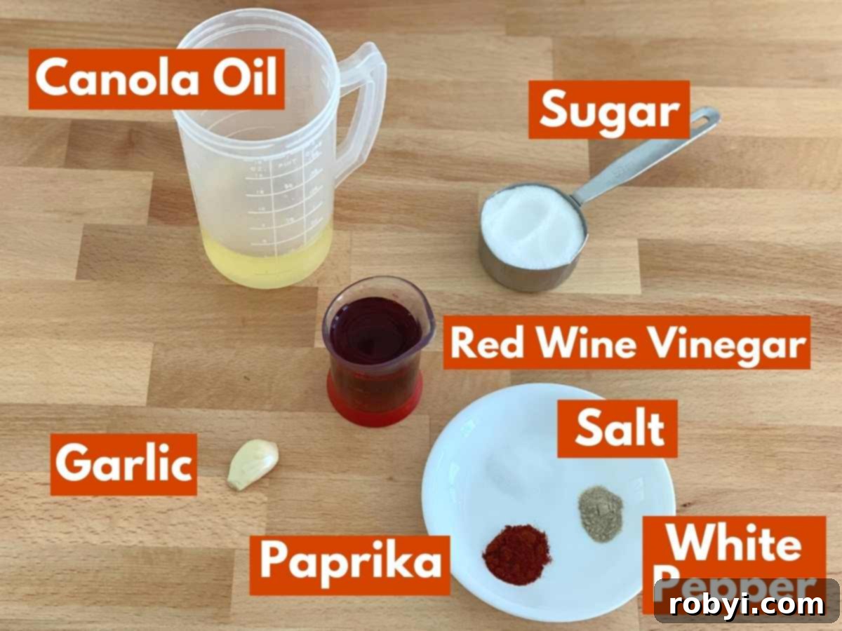 All the essential ingredients neatly laid out for making the Sweet Red Wine Vinaigrette Dressing, including canola oil, red wine vinegar, sugar, fresh garlic, salt, paprika, and white pepper.