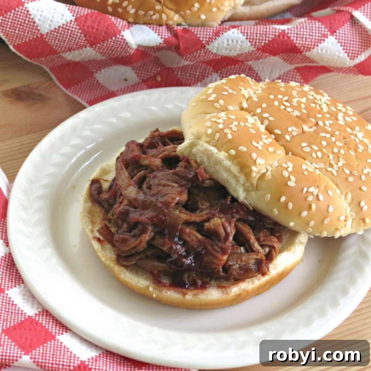 Sweet and Tangy Blackberry Slow Cooker Pulled Pork Tenderloin 2 Slow cooker pulled pork tenderloin in a blackberry bbq sauce on a bun.