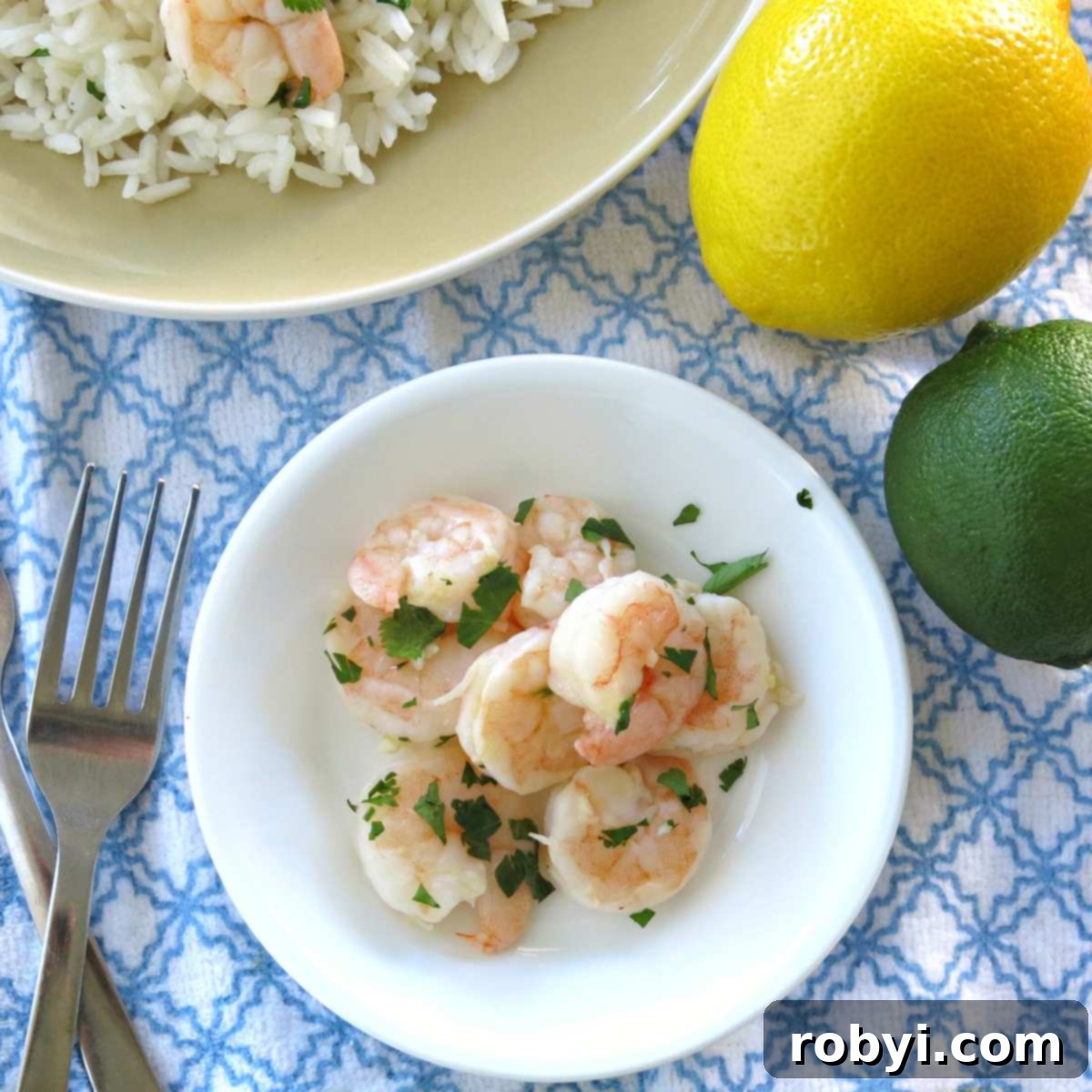 Chilled cilantro lime shrimp elegantly arranged on a plate with forks, garnished with lime wedges and cilantro.