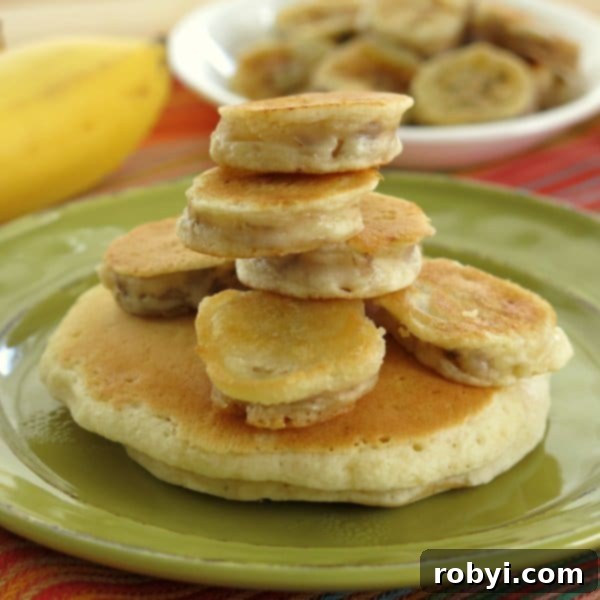 Sweet Fluffy Banana Pancakes 2 Golden-brown battered banana medallions stacked on a green plate, ready to be enjoyed.