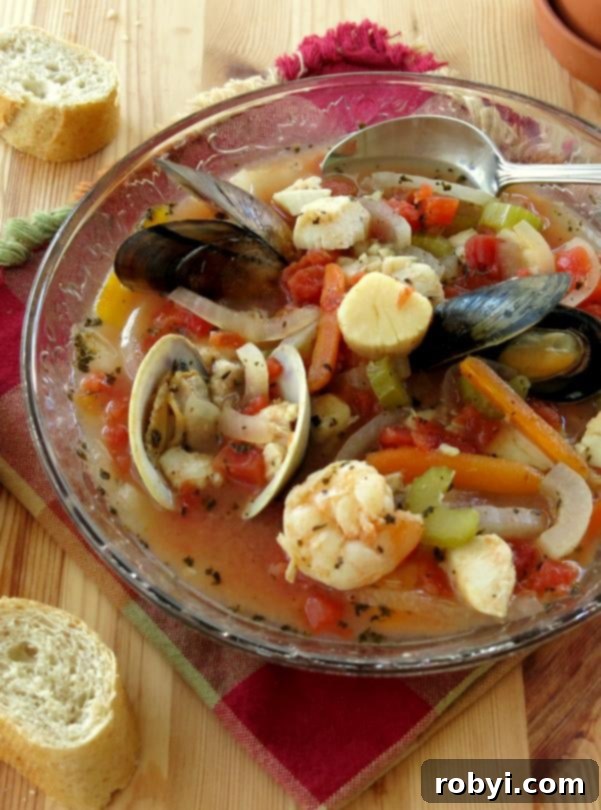 Easy Italian Seafood Stew in bowl with spoon and bread on the side
