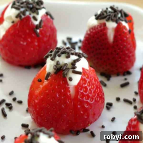 3 No-bake cheesecake stuffed strawberries on a plate topped with sprinkles.