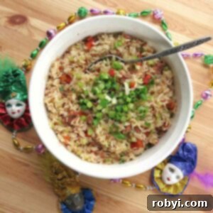 Easy Cajun Dirty Rice with sausage in bowl surrounded by Mardi Gras beads, ready to be served.