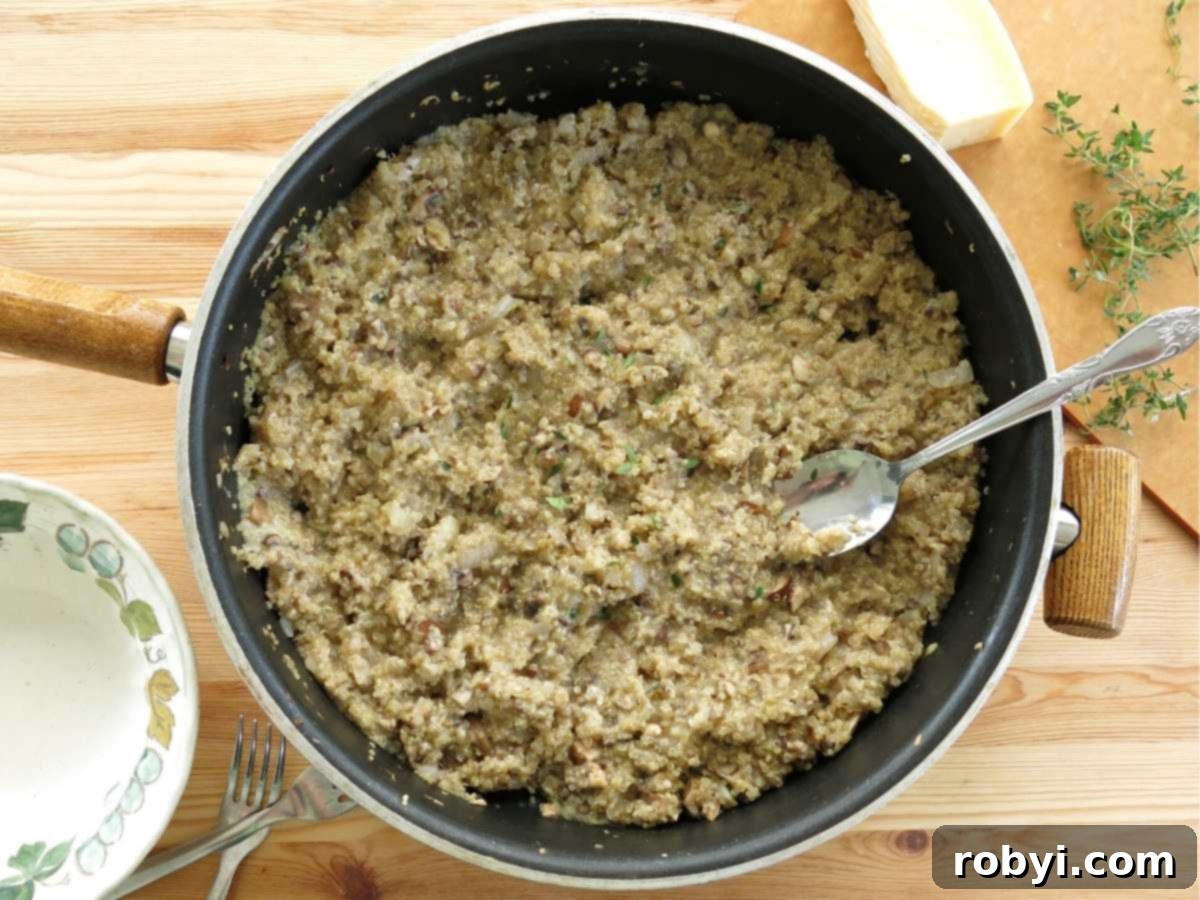 Creamy mushroom quinoa risotto in a large skillet, steaming gently after cooking.