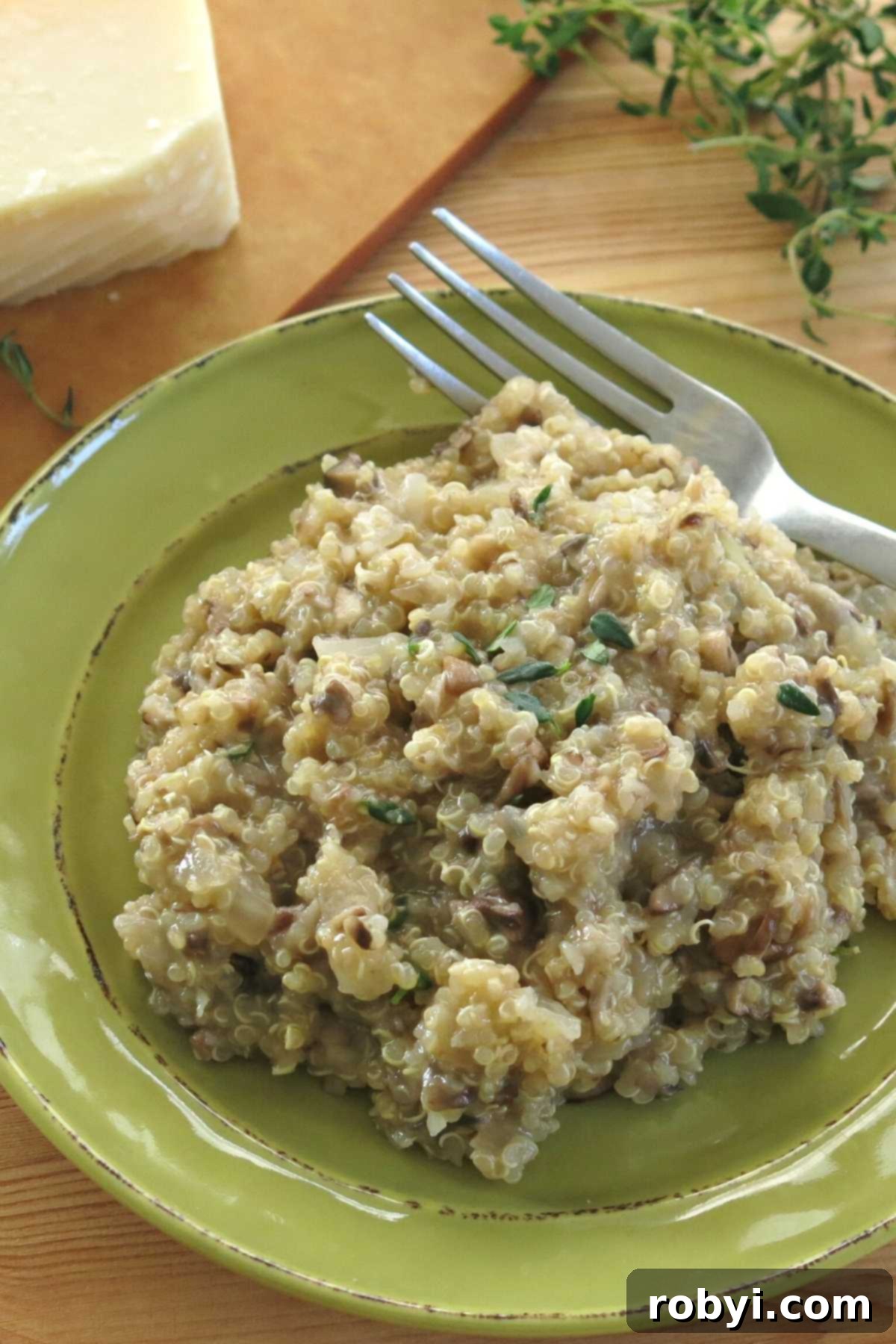 Plate with mushroom quinoa risotto, generously sprinkled with fresh thyme for garnish.