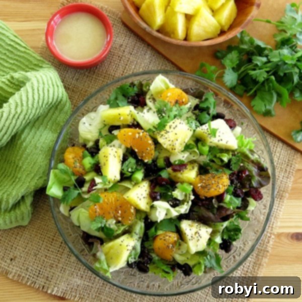 A single serving of Caribbean Salad with Honey Lime Dressing on a plate, topped with black beans for a complete meal.