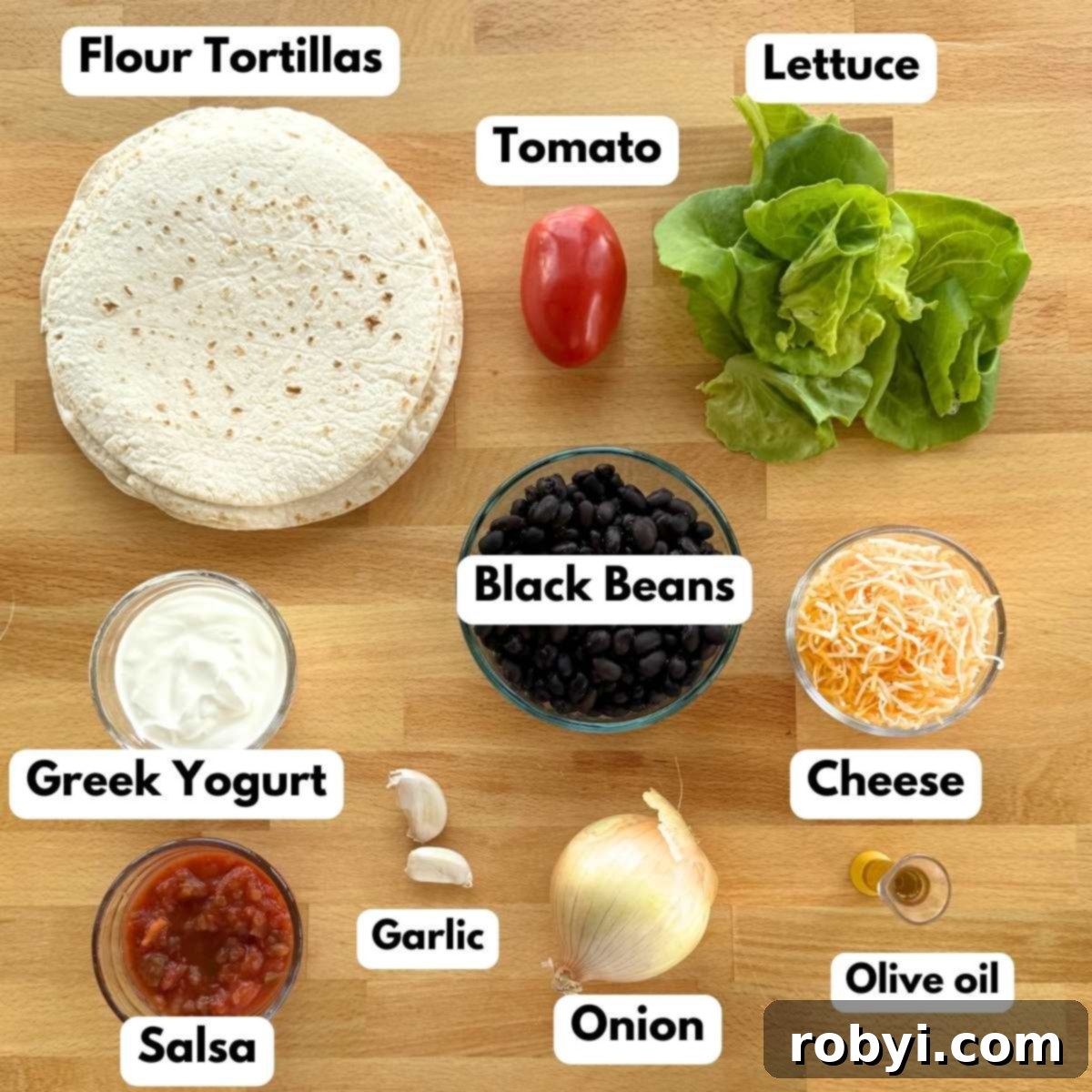 A vibrant flat lay showing all the fresh ingredients needed to make the black bean wraps: a stack of flour tortillas, a bowl of black beans, bowls of Greek yogurt, salsa, and shredded cheese, along with fresh onion, garlic cloves, crisp lettuce leaves, and a ripe Roma tomato.