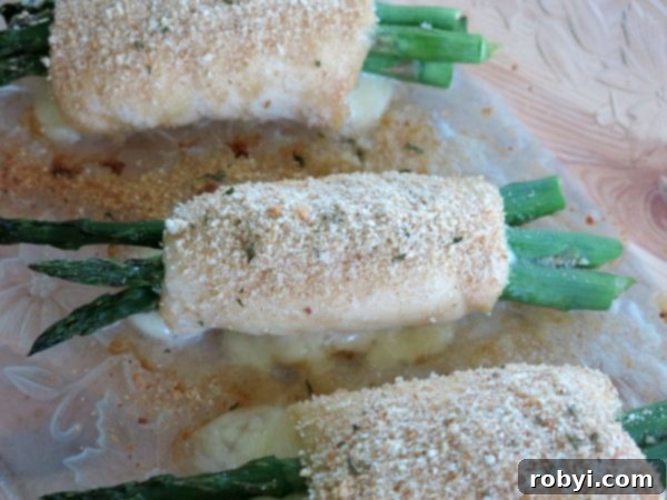 Asparagus wrapped chicken baking in a ceramic dish, golden and juicy