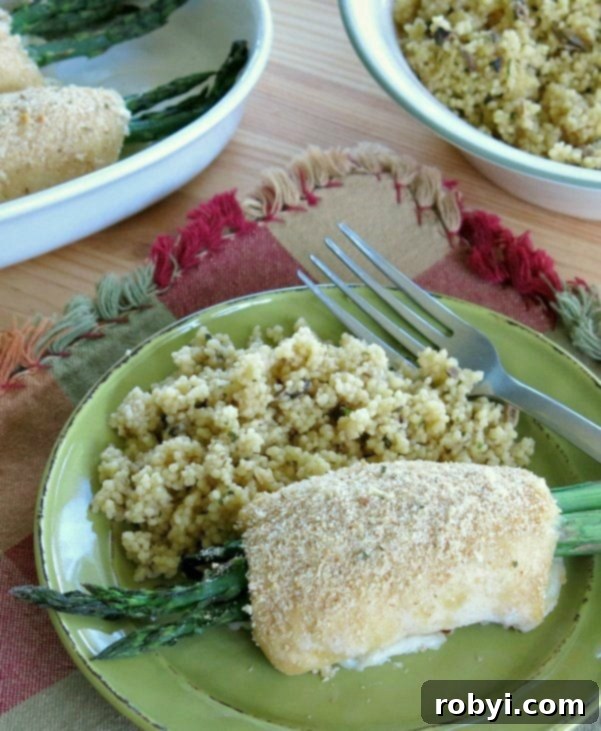 Close-up of baked chicken wrapped asparagus, sliced open on a plate