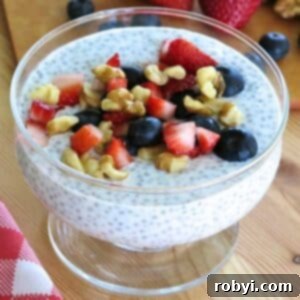 Overnight chia seed pudding made with Greek yogurt and topped with fresh strawberries, blueberries, and chopped walnuts in a glass bowl.