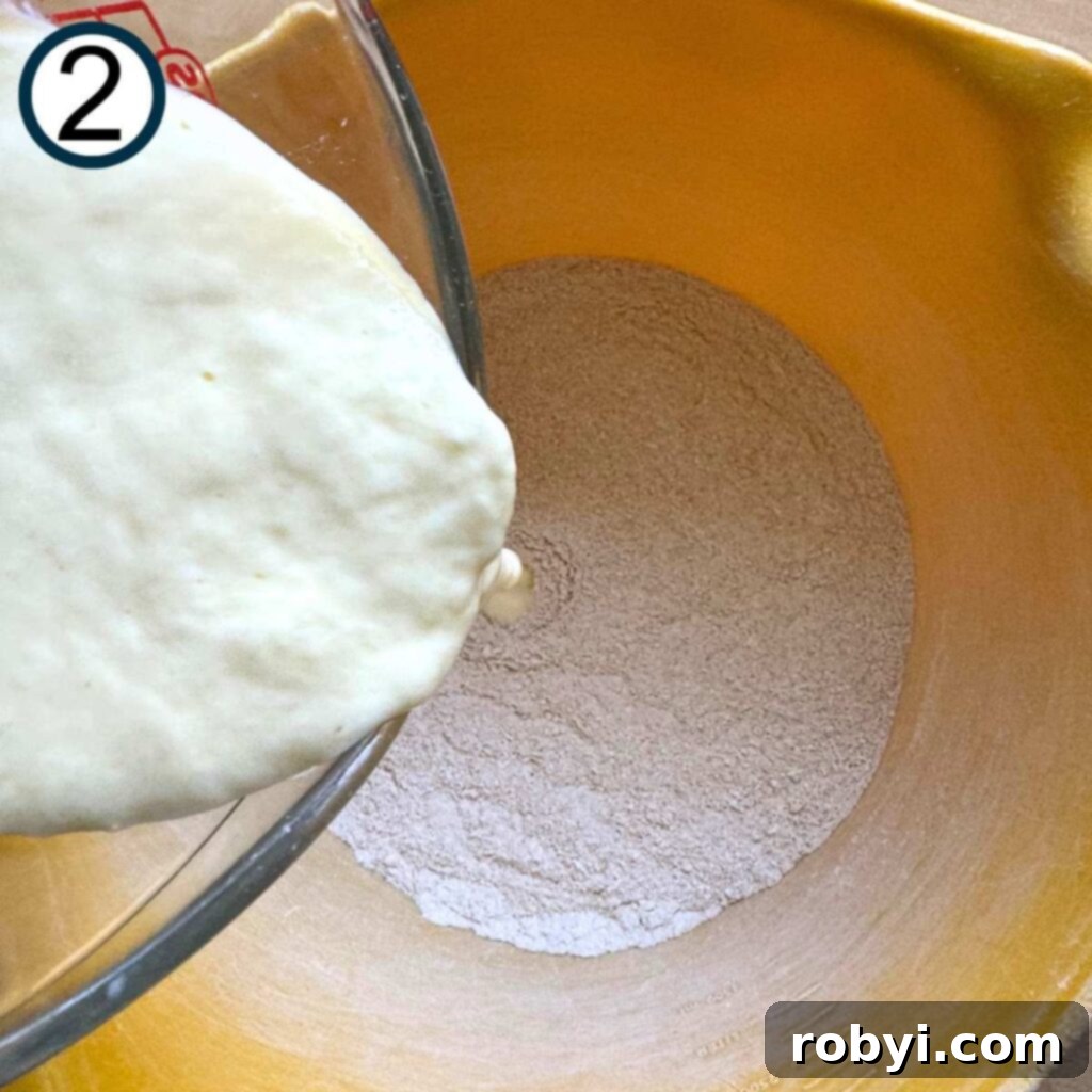 Whisked egg and Greek yogurt mixture being poured into a bowl with the dry ingredients for banana muffins, illustrating the combining step.