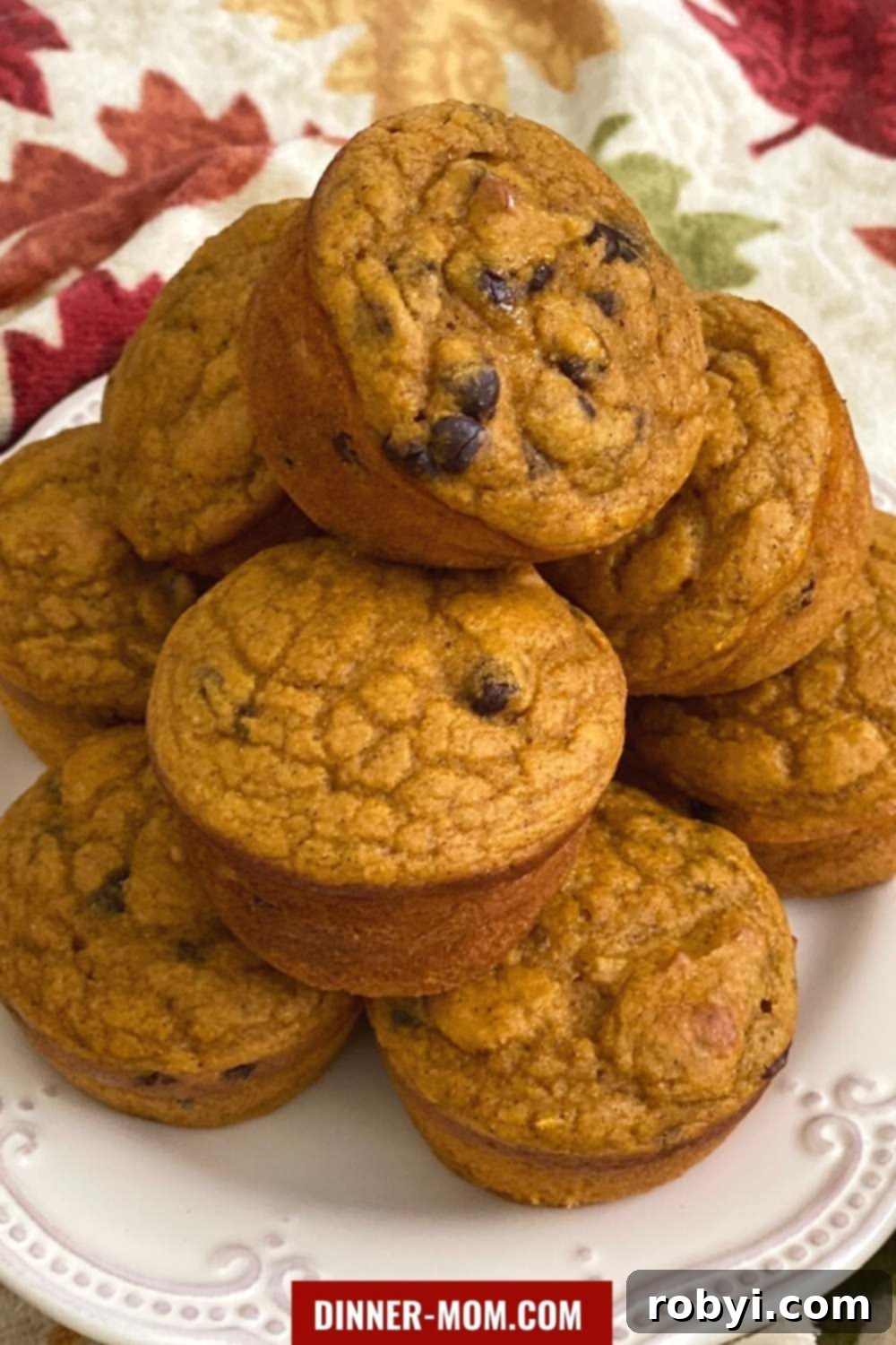 A stack of perfectly baked healthy pumpkin muffins, golden brown and inviting, arranged artfully on a plate.