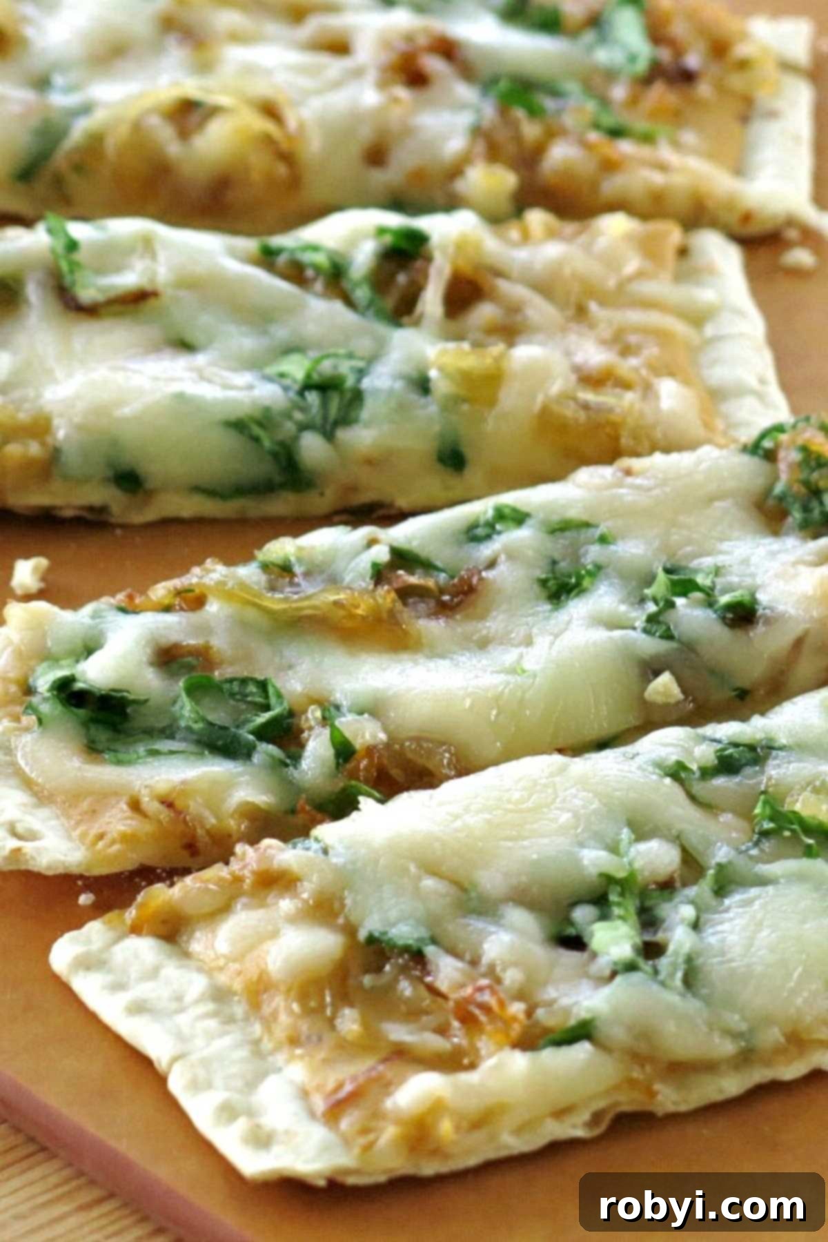 Perfectly cut slices of pumpkin flatbread pizza arranged on a wooden cutting board, inviting you to take a bite.