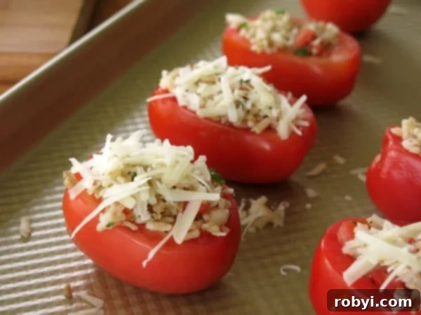 Easy Four Ingredient Rice Stuffed Tomatoes 5 Rice and Sausage Stuffed Tomatoes arranged on a baking sheet, ready for the oven