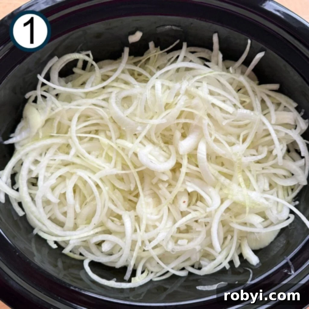 Thinly sliced onions filling a slow cooker, ready for cooking.