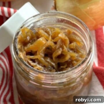 Caramelized onions in a glass mason jar with white lid resting against the side of the jar.