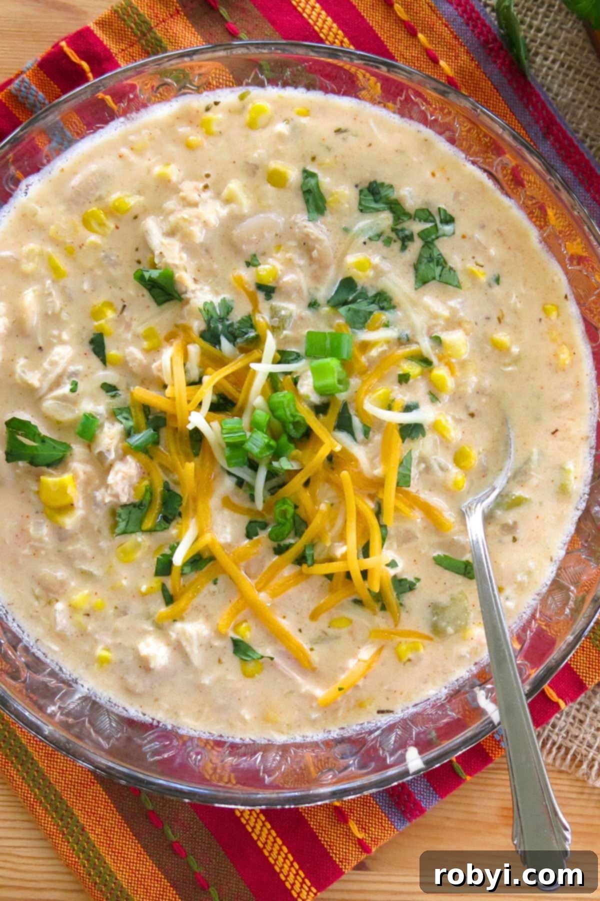 Cream Cheese Dream White Chicken Chili 6 Bowl of white chicken chili topped with shredded cheese, sliced green onions, and cilantro.