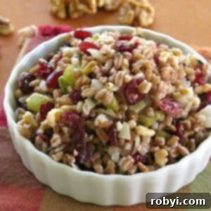 Farro stuffing with cranberries, walnuts, onion, and celery in a serving bowl.