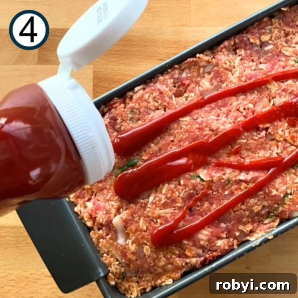 Meatloaf mixture added to a loaf pan and layered with ketchup on top for the glaze.
