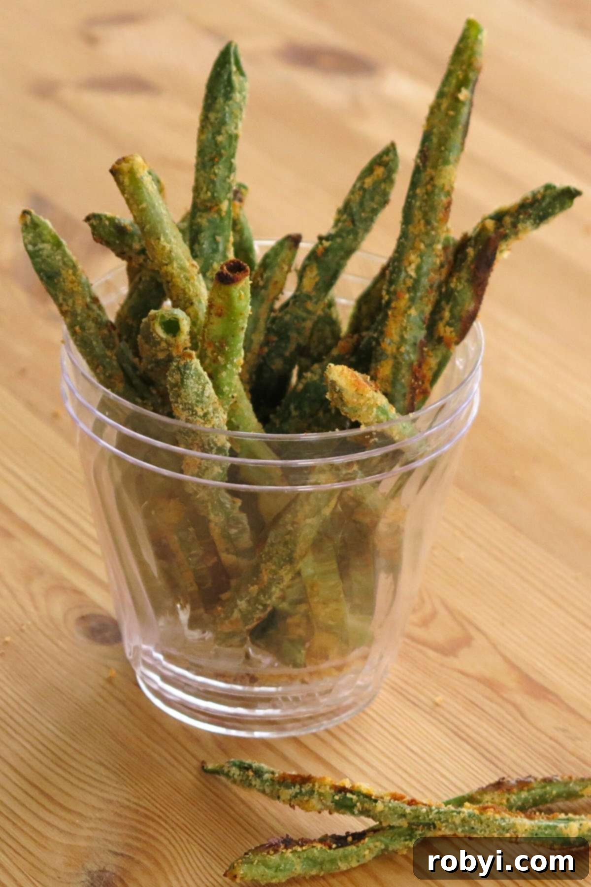 Oven-Crisped Green Bean Fries 4 Keto green bean fries standing upright in a clear glass cup, ready for a party.