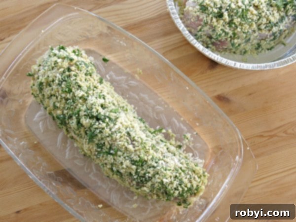 Aromatic Herb-Roasted Pork Tenderloin 4 Uncooked Breaded Pork Tenderloin with Herb Crust in a freezer-safe baking dish, ready for storage or baking