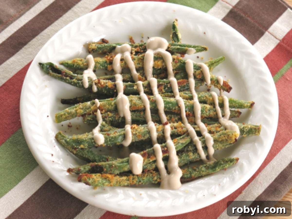 White plate with Parmesan crusted green bean fries drizzled with a balsamic yogurt sauce.