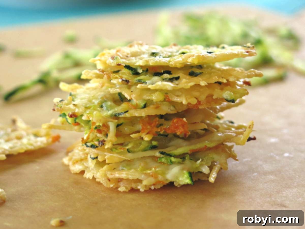 Stack of eight Parmesan crisps with shredded zucchini and carrots. 