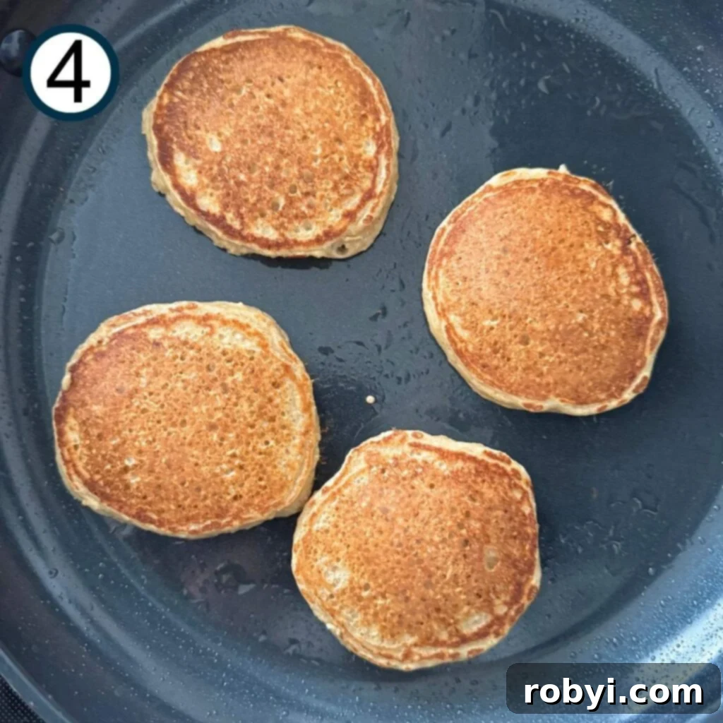 Cooked cottage cheese oat pancakes in a non-stick skillet